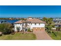 Two-story waterfront home with tile roof, three-car garage, and lush landscaping at 24248 Treasure Island Blvd, Punta Gorda, FL 33955