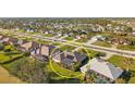 Aerial view of property highlighting the caged pool, solar panels, landscaping, and surrounding neighborhood at 290 Rotonda E Blvd, Rotonda West, FL 33947