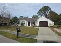 Charming single-story home with a dark brown garage door and neat landscaping at 3261 Mill Run Ct, North Port, FL 34287