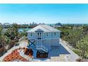 Charming coastal home with a metal roof, tidy landscaping, and a white stair entrance at 37 Bocilla Dr, Placida, FL 33946