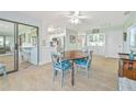 Cozy dining room featuring light blue walls, wood-look tile, and views of the kitchen and screened-in porch at 3871 Bordeaux Dr, Punta Gorda, FL 33950