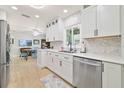 Modern kitchen featuring white cabinets, stainless steel appliances, quartz countertops, and a stylish backsplash at 3871 Bordeaux Dr, Punta Gorda, FL 33950