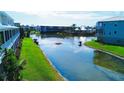 Scenic view of the community pond and surrounding buildings, offering a peaceful and serene atmosphere with lush greenery at 10311 Lands End Cir # 16, Placida, FL 33946
