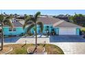 Charming, turquoise single-story home featuring a well-manicured lawn and spacious driveway at 121 Sinclair Se St, Port Charlotte, FL 33952