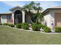 Attractive home with manicured lawn, front garden, and a charming entrance with an arched doorway at 1247 Petronia St, North Port, FL 34286