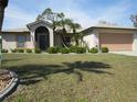 Inviting home featuring a well-manicured lawn, lush landscaping, and a welcoming front entrance at 1247 Petronia St, North Port, FL 34286