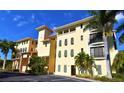 Beautiful condo complex with mature palm trees and vibrant yellow exterior at 1340 Rock Dove Ct # 143, Punta Gorda, FL 33950