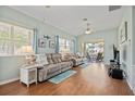 Bright living room with wood floors, ceiling fan, and access to an outdoor patio at 1706 Fountain View Cir, Venice, FL 34292
