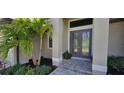 This home's front entrance features a lovely tiled step-up, fresh landscaping, and a charming double-door entry way at 17350 Bayharbor Cir, Port Charlotte, FL 33948