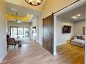 Open concept living space features modern tile floors, tray ceilings, a sliding barn door, and easy access to the pool at 17350 Bayharbor Cir, Port Charlotte, FL 33948