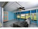 Bright sunroom with tile flooring and a comfortable gray couch at 18130 Steele Ave, Port Charlotte, FL 33948