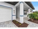 Covered entryway with paver walkway and white garage door at 1890 Sunset Preserve Way, Port Charlotte, FL 33953