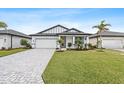 New construction home with paver driveway and landscaped lawn at 1890 Sunset Preserve Way, Port Charlotte, FL 33953