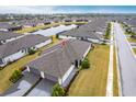 Beautiful aerial view of house and community pond, with landscaped lawns and paver driveways at 1912 Saddlewood Cir, Port Charlotte, FL 33953