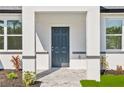 Close-up of the home's entrance showing a stylish front door and inviting landscaping, enhancing curb appeal at 2143 S Haberland Blvd, North Port, FL 34288