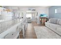 Open-concept living area with modern white kitchen, bar seating, and a comfortable seating area at 21923 Cellini Ave, Port Charlotte, FL 33952