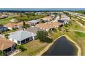 Aerial view of a home with a screened-in porch, surrounded by a golf course and a pond at 24576 Buckingham Way, Punta Gorda, FL 33980