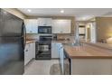 Modern condo kitchen with white cabinetry and stainless steel appliances at 25100 Sandhill Blvd # J-201, Punta Gorda, FL 33983