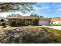 Charming single-story home featuring a well-manicured front lawn and an attached two-car garage at 27199 Punta Cabello Ct, Punta Gorda, FL 33983