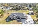 Aerial view of single story house with gray exterior, attached garage, and long concrete driveway at 4175 Horseshoe Ave, North Port, FL 34286