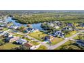 Aerial view of home situated on waterfront canal, surrounded by lush greenery and other residences at 4254 Bur St, Port Charlotte, FL 33948