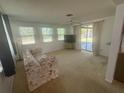 Inviting living room with large windows, ceiling fan, and sliding glass doors to the patio at 432 Olivia Rd, Venice, FL 34293