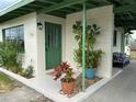 Quaint front entrance with green door and lush landscaping at 761 Dalton Blvd, Port Charlotte, FL 33952