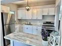 Modern kitchen with white cabinets and stainless steel appliances at 761 Dalton Blvd, Port Charlotte, FL 33952