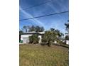 Front view of the single story home with trees and grass in the yard at 8152 Robert St, Englewood, FL 34224