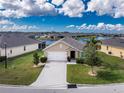 Charming single Gathering home with a two car garage, lush lawn, and serene lake view at 7049 Waterford Pkwy, Punta Gorda, FL 33950