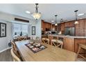 Dining room with a modern light fixture, adjoining the kitchen area, and a bright window view at 1212 Yachtsman Ln, Punta Gorda, FL 33983