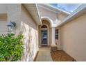 An arched entryway leads to the front door with a sidelight window and exterior light fixture at 1578 Scarlett Ave, North Port, FL 34289