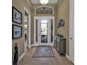 Welcoming foyer with wood flooring, decorative rug, and an elegant cabinet at 1620 Lancashire Dr, Venice, FL 34293