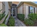 Inviting front entrance with a screened porch and stone pathway surrounded by manicured bushes at 1620 Lancashire Dr, Venice, FL 34293