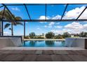 Relaxing pool area featuring dual waterfall features and an enclosed screened-in lanai overlooking lush greenery and open skies at 17122 Barcrest Ln, Punta Gorda, FL 33955