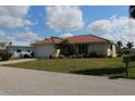 Inviting single-story home with a red tile roof, green lawn, and a quaint bicycle parked outside at 1727 Boca Raton Ct, Punta Gorda, FL 33950