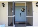 Screened entryway showcasing a blue double door with decorative accents and tiled flooring at 1727 Boca Raton Ct, Punta Gorda, FL 33950