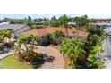 Beautiful one-story home with a tile roof, brick driveway, and tropical landscaping at 2284 Palm Tree Dr, Punta Gorda, FL 33950