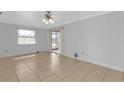 Bright living room featuring tile floors, modern ceiling fan, and sliding glass doors to the outside at 25068 Harborview Rd # 3B, Punta Gorda, FL 33980