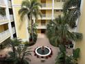 Bird's eye view of a tranquil courtyard featuring a fountain, lush greenery, and manicured landscaping at 255 West End Dr # 1302, Punta Gorda, FL 33950