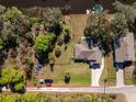 Aerial view of a home with a large yard, waterfront access, and boat parking at 27385 Neaptide Dr, Punta Gorda, FL 33983