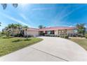 Attractive single-story home with a long driveway, stone accents and a red roof at 35 Sabal Dr, Punta Gorda, FL 33950