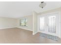 Bright living room featuring tile flooring, neutral walls and a large double door entryway at 35 Sabal Dr, Punta Gorda, FL 33950