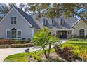 Charming home with a gray tile roof, lush landscaping, and a paved walkway leading to the front door at 4 Saint Martin Cir, Englewood, FL 34223