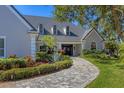 Beautiful home showcasing lush landscaping, arched windows, and a welcoming, paved walkway at 4 Saint Martin Cir, Englewood, FL 34223