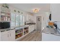 Bright kitchen featuring white cabinets, granite countertops, open storage, and a window for natural light at 4383 Mckibben Dr, North Port, FL 34287