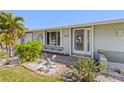 Charming home exterior featuring a decorative dolphin themed glass front door and manicured garden bed at 5196 Early Ter, Port Charlotte, FL 33981