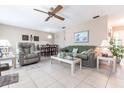 Inviting living room featuring tile flooring, comfortable seating, a ceiling fan and view into dining area at 8029 Roy Dr, Punta Gorda, FL 33982