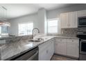 Kitchen featuring granite countertops, stainless steel appliances, and white cabinets at 8403 Placida Rd # 408, Placida, FL 33946