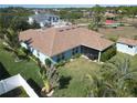 Single-story home featuring a screened lanai and spacious backyard with lush landscaping and a storage shed at 9175 Melody Cir, Port Charlotte, FL 33981